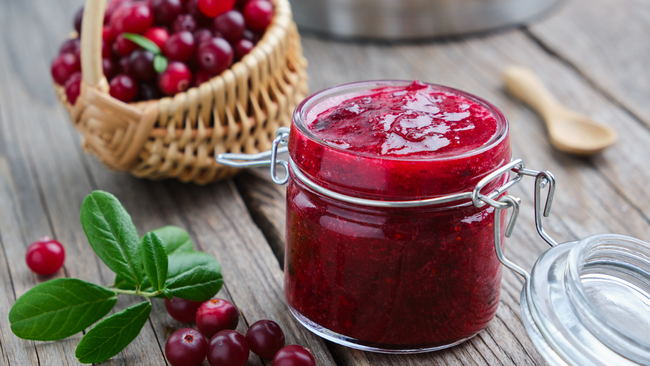 cranberry jelly with fresh cranberries on a wooden table