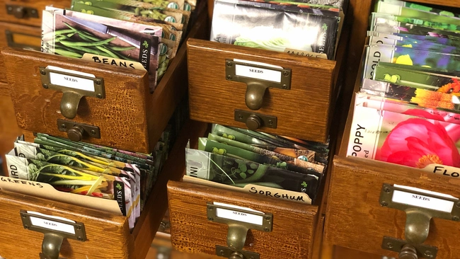 Packages of seeds organized into labeled drawers