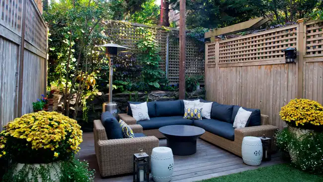 Patio. Garden. Urban, neutral, outdoor living space. Exterior photo. Outdoor living room with couch, comfy cushions, throw pillows, love seat, chairs and coffee table. Backyard with greenery, plants.