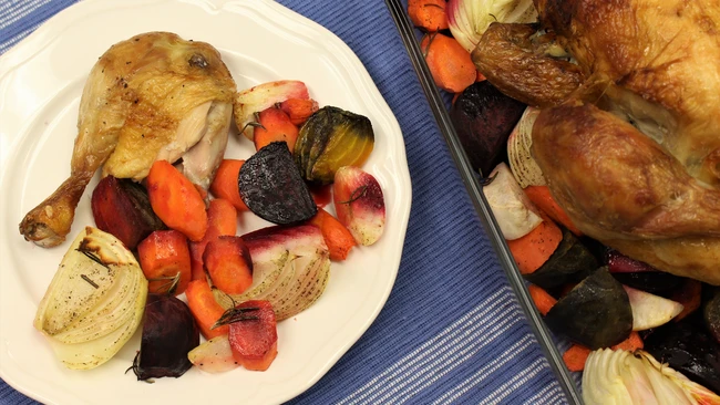 chicken leg on a plate with roasted root vegetables