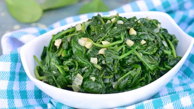 sauteed spinach and garlic and shallots in a white bowl